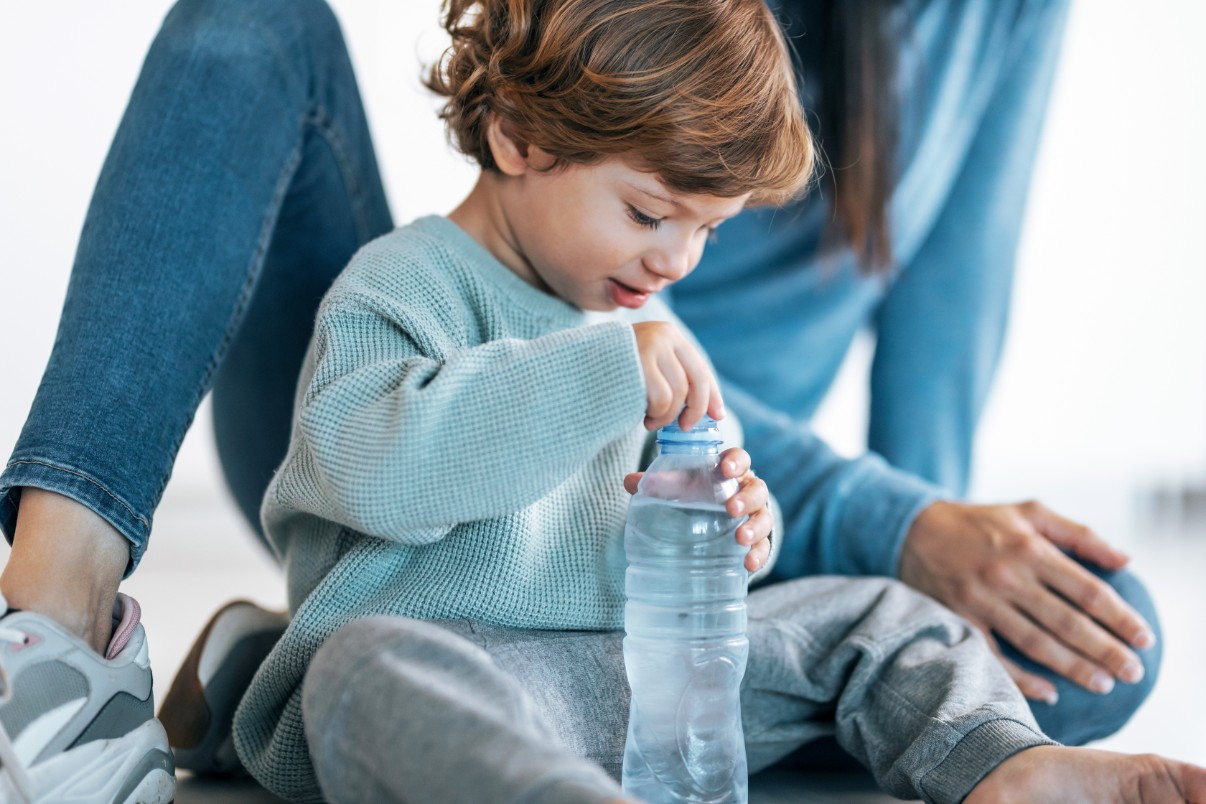 A child putting a cap on a bottle A child putting a cap on a bottle