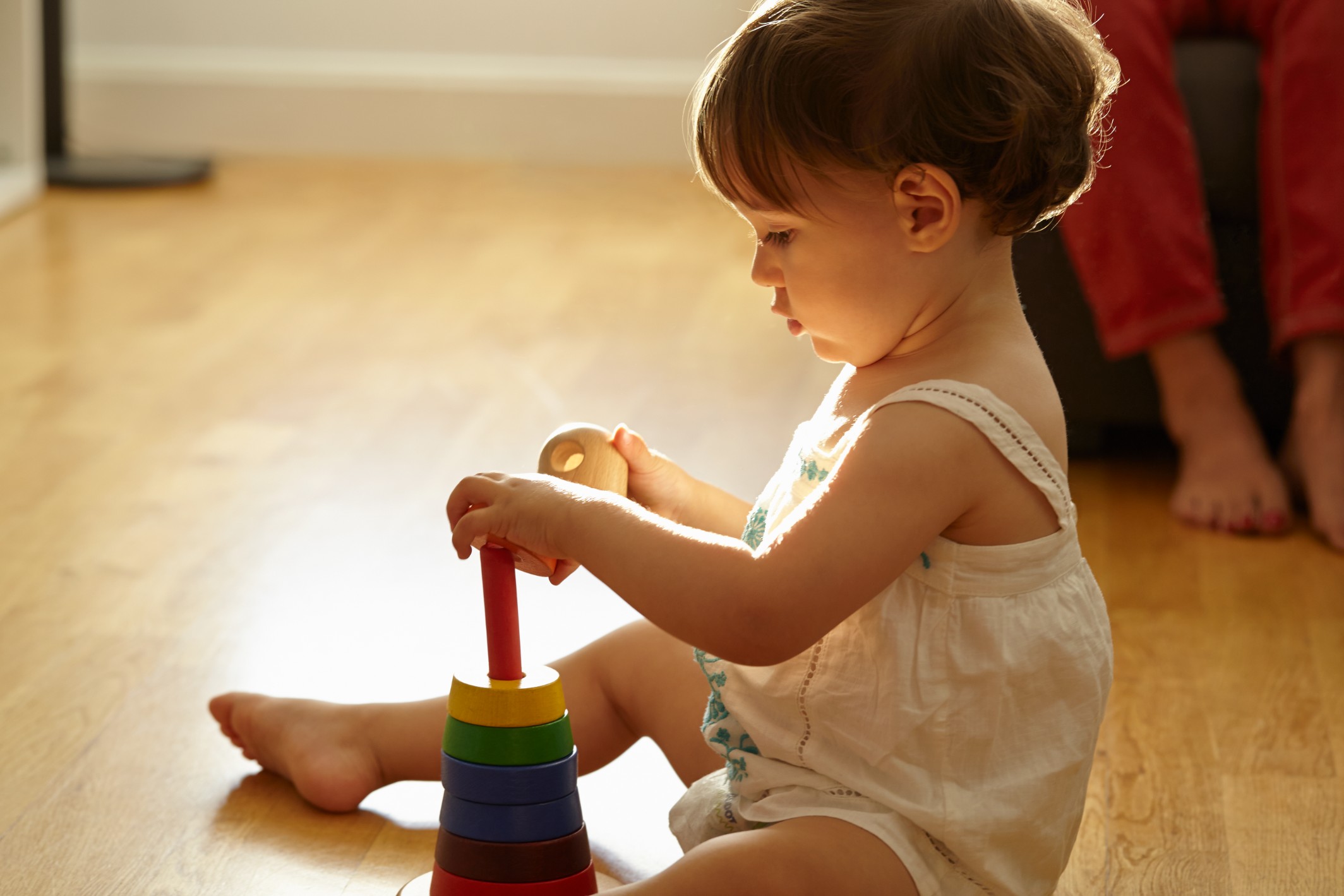 Renkli diskleri üst üste dizme aktivitesi yapan bir çocuk A child stacking colorful disks