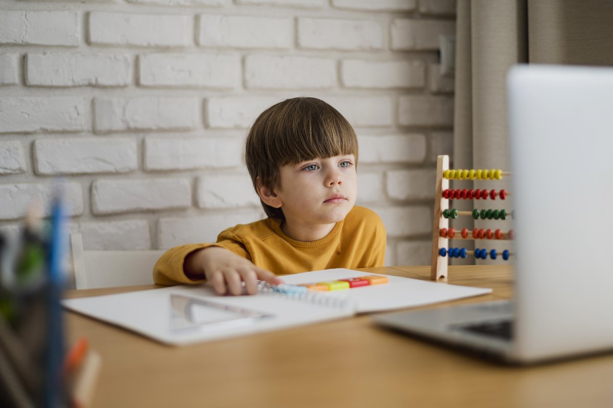 A boy studying a learning material in a table setting A boy studying a learning material in a table setting