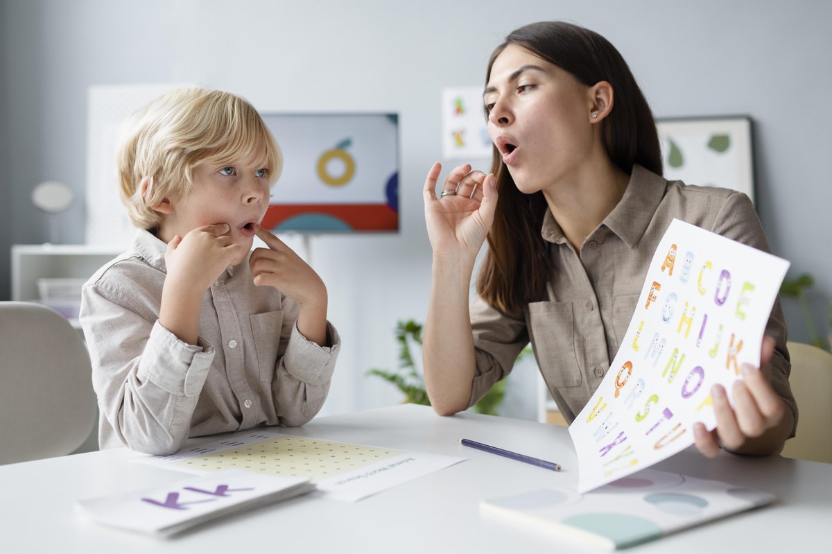 a boy performs pronunciation practice with a language and speech therapist